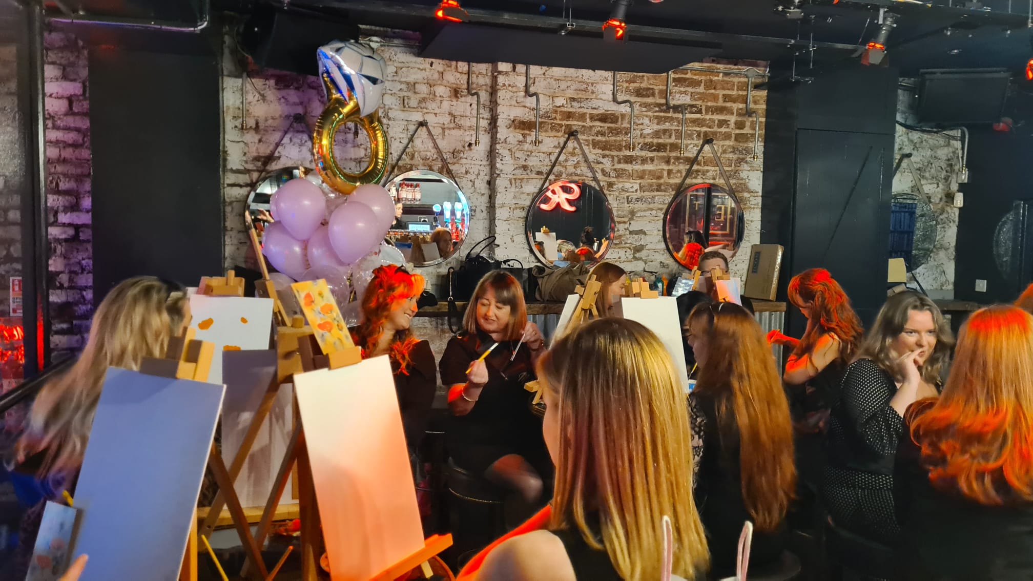 A group participating in "Paint and Prosecco", which is a group activity for a hen party, wedding, or a birthday party.